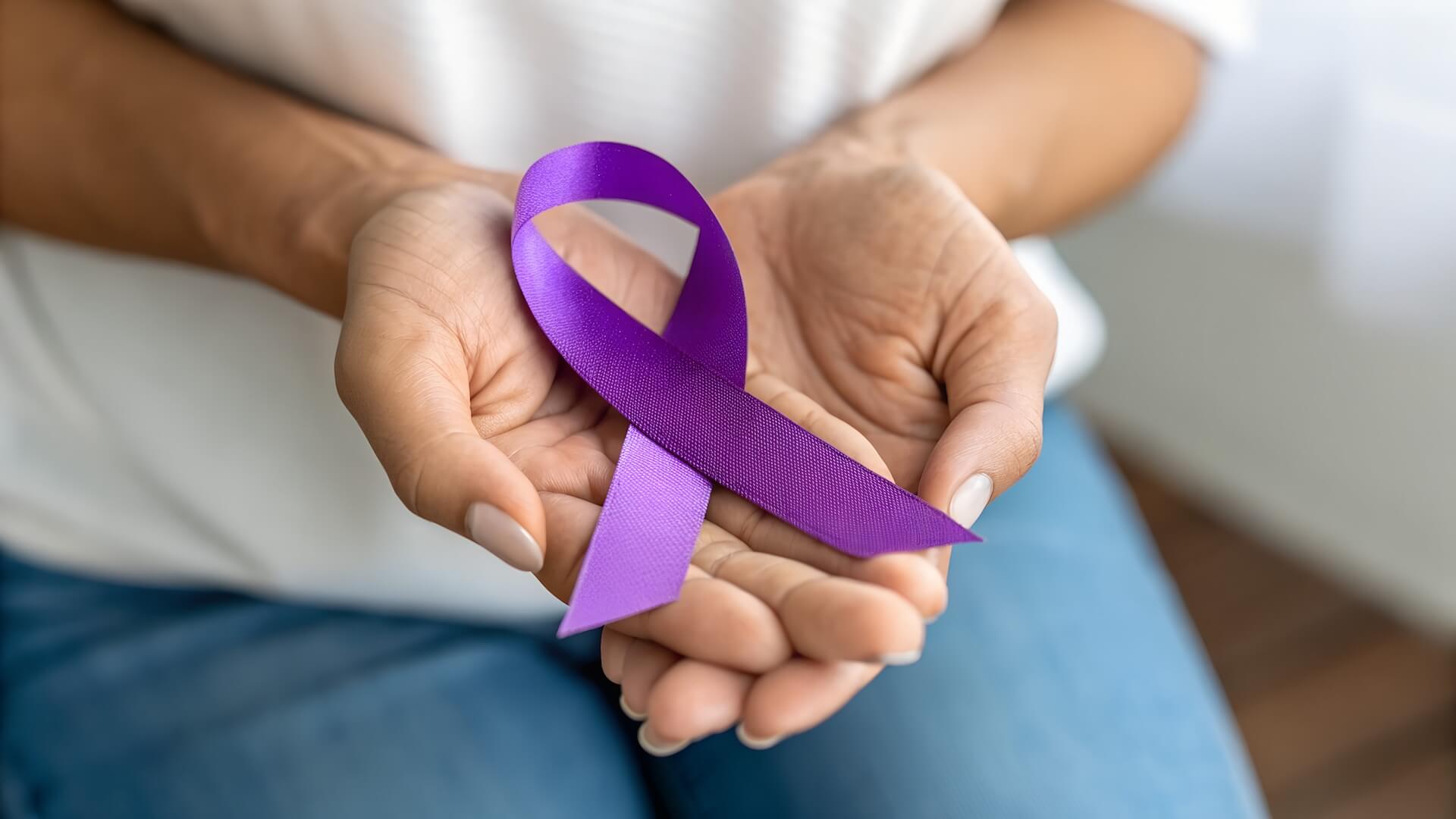 Hands holding purple fibroid awareness ribbon representing Fibroid Awareness Month and fertility health