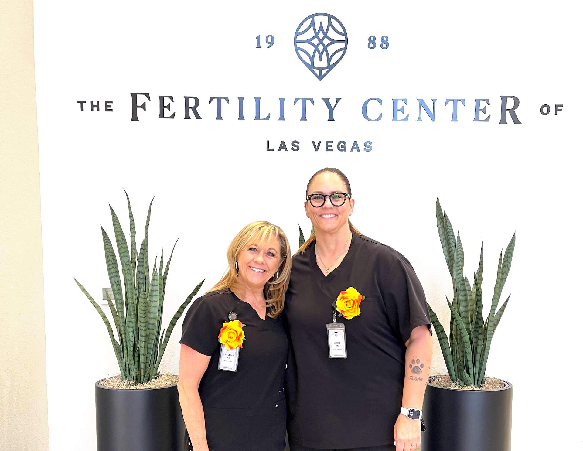 FCLV nurses Lesleigh Pena and Jaime Principe smiling in front of The Fertility Center of Las Vegas sign recognized for life-saving actionsrecognized for life-saving actions