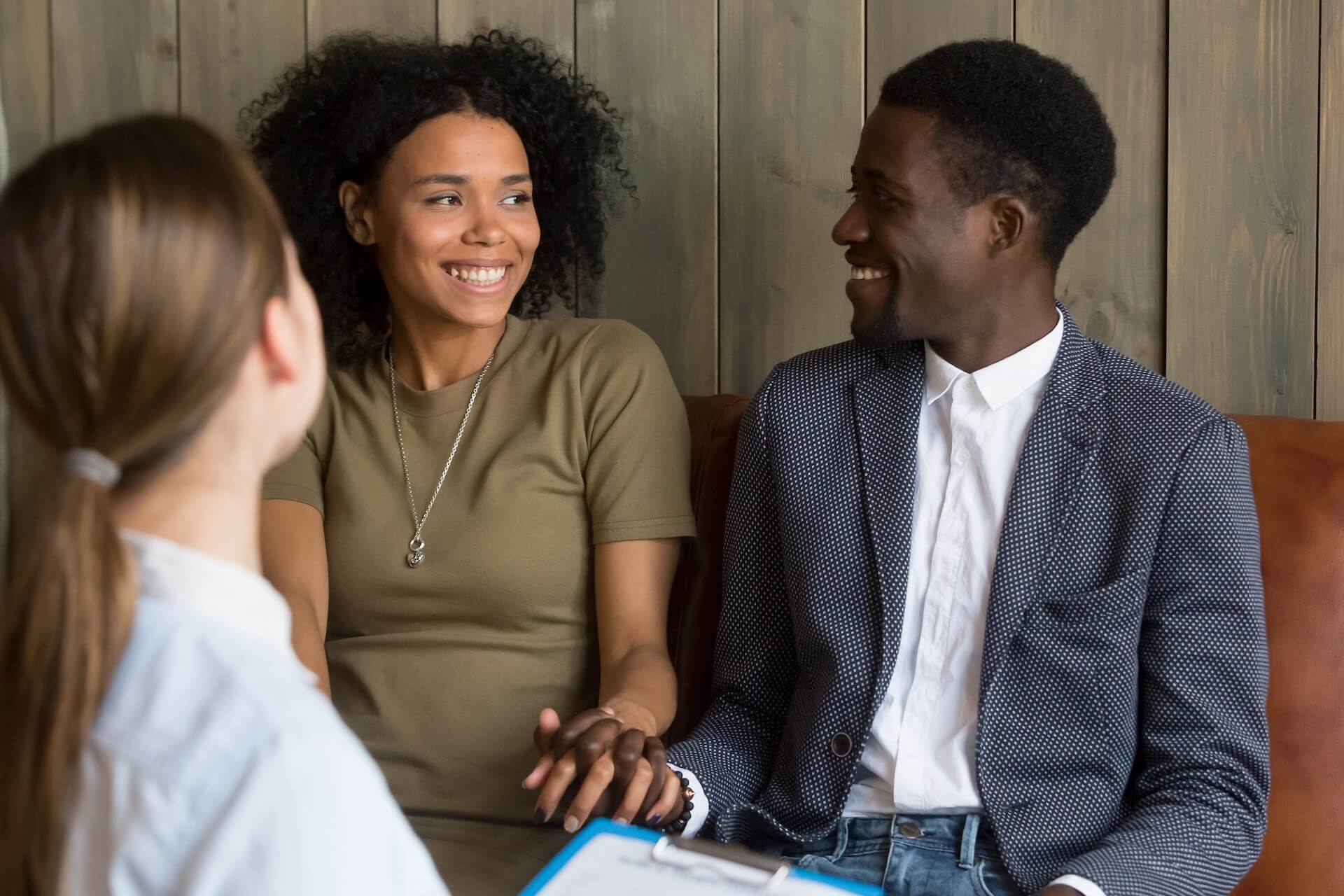 Couple smiling and holding hands during their first fertility consultation with a doctor at The Fertility Center of Las Vegas