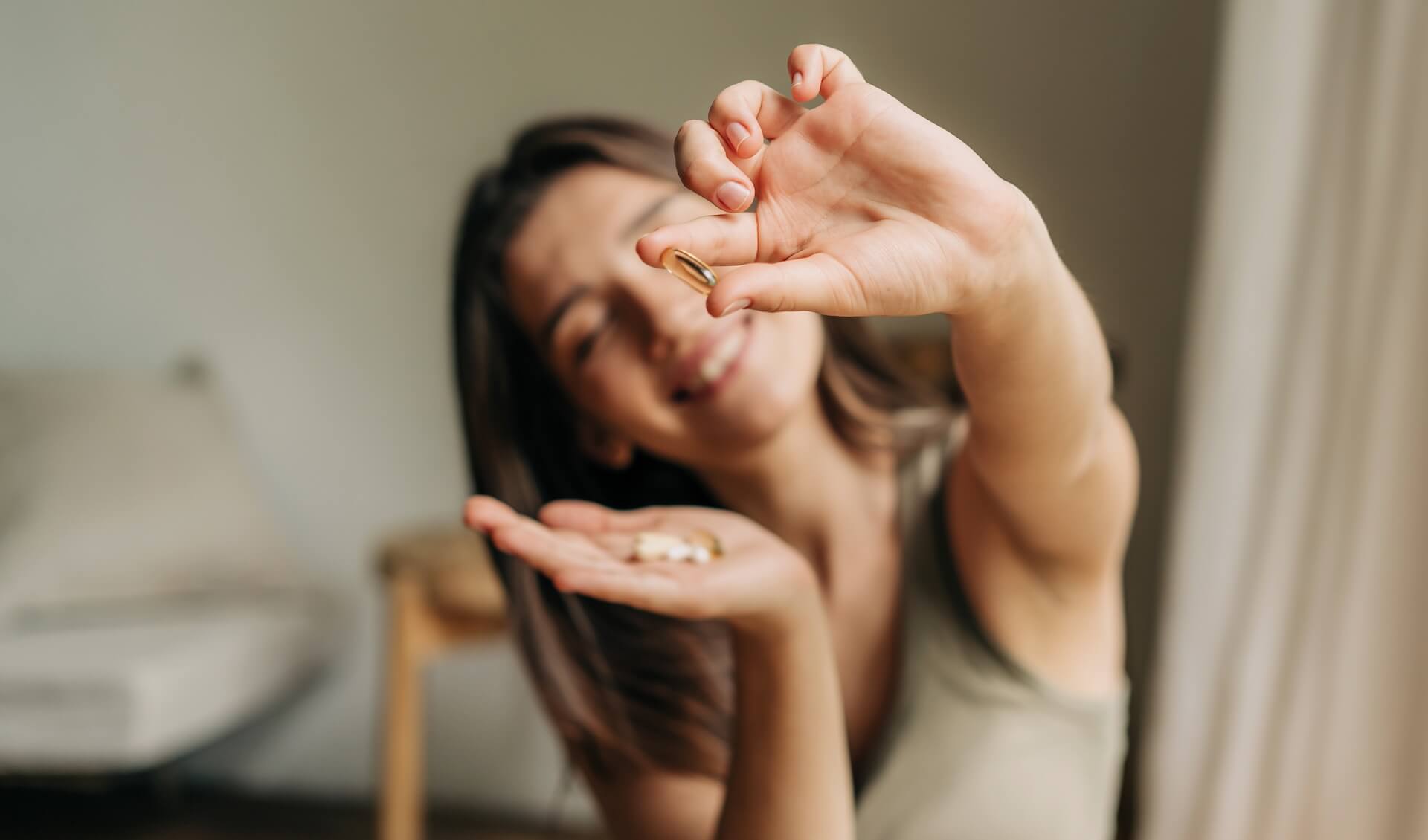 Woman holding supplement capsule at home representing fertility supplements for women and conception support options