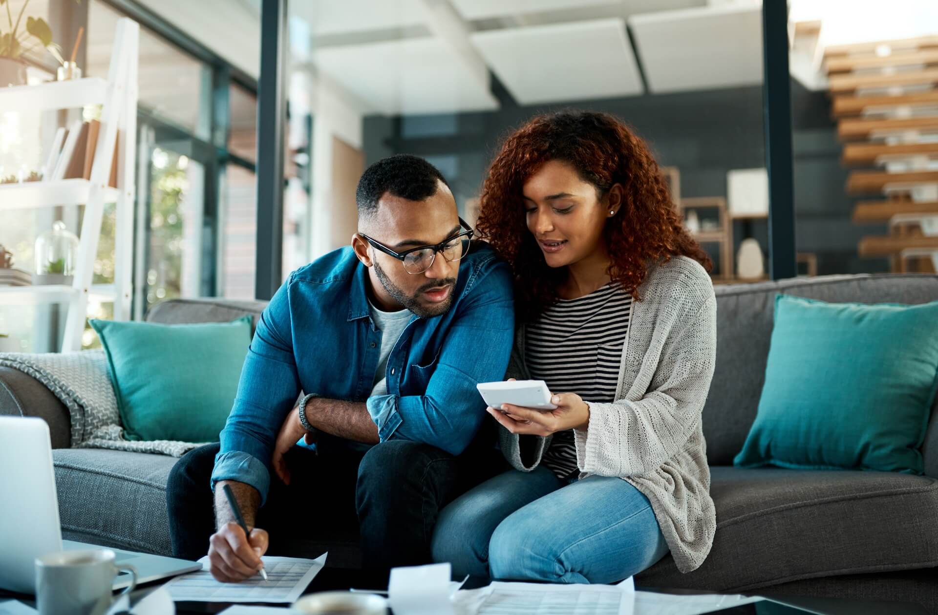 Couple reviewing documents together at home researching and breaking down IVF costs and fertility treatment expenses